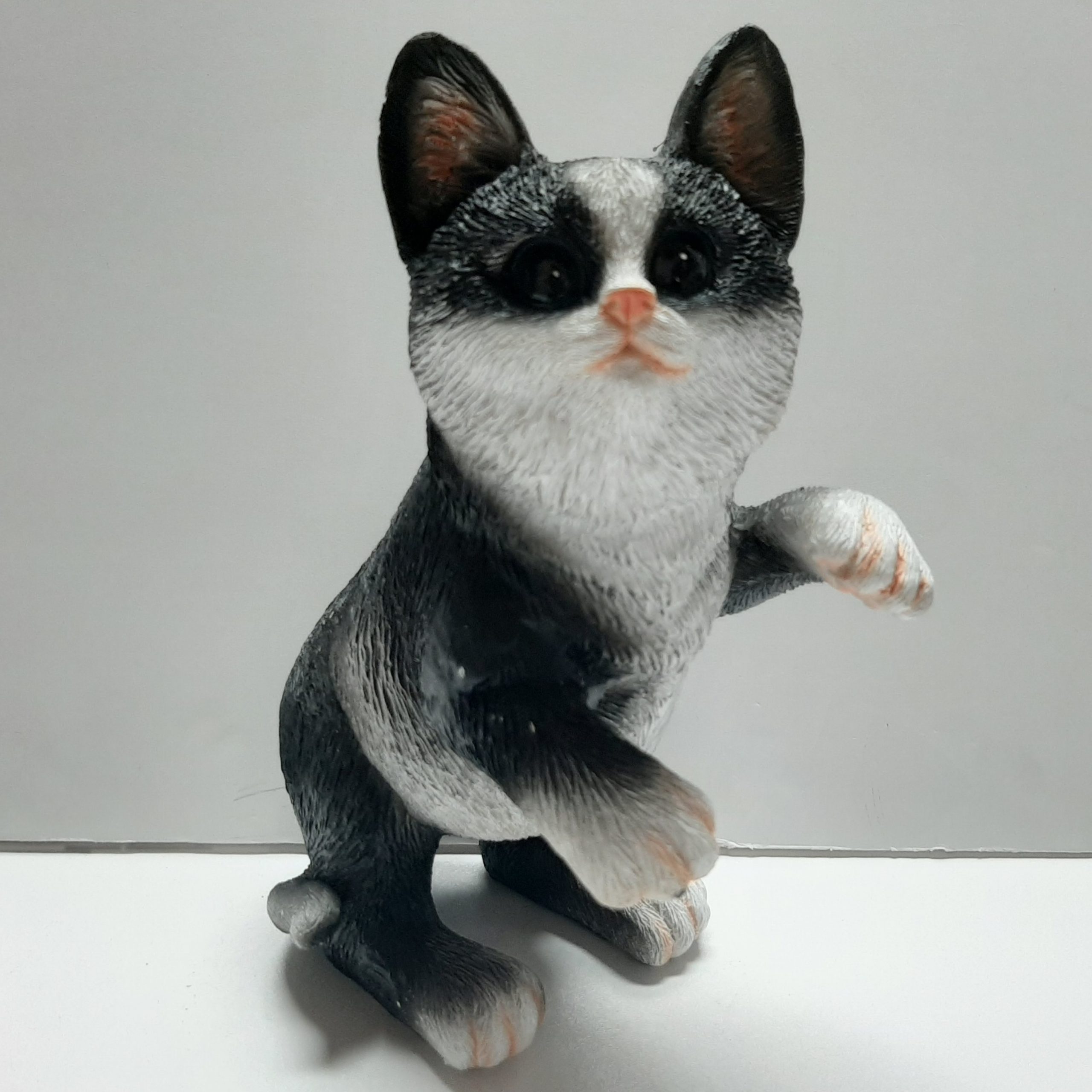 Levensecht beeldje van spelende zwart witte kat, 21 cm hoog