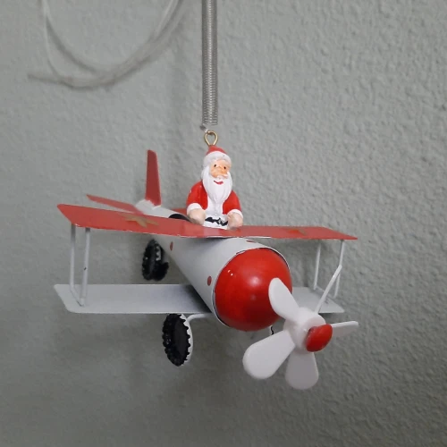Springveer kerst-kerstman in vliegtuig
