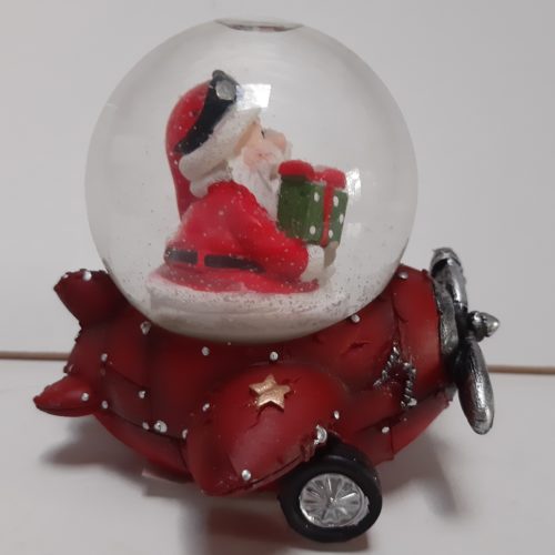 Sneeuwbol kerstman in rood vliegtuig met groen cadeau