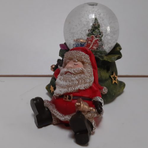 Sneeuwbol slapende kerstman op groene zak in 3d met in de bol kerstboom en cadeaus 7cm hoog