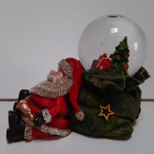 Sneeuwbol slapende kerstman op groene zak in 3d met in de bol kerstboom en cadeaus 7cm hoog